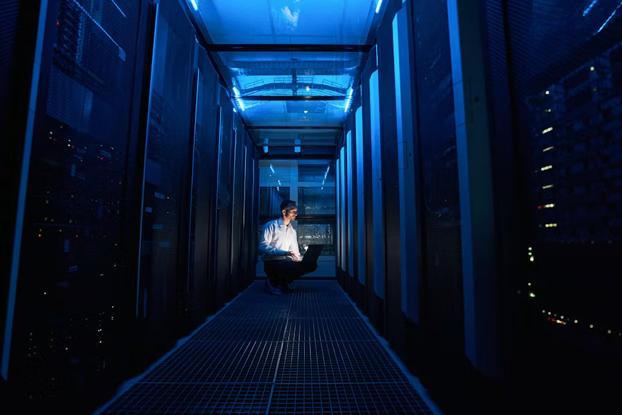 Data center engineer working inside a large-scale server rack facility