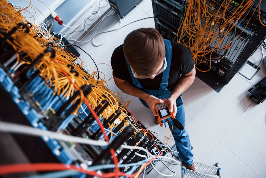 Data center technician managing server cable infrastructure as part of a high demand career in data center operations